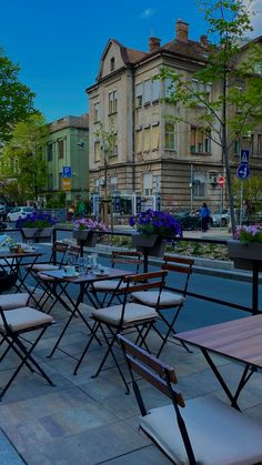 tables and chairs are lined up on the sidewalk