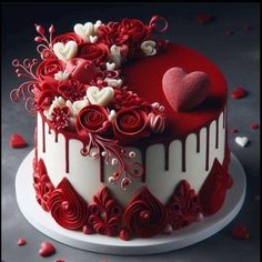 a red and white decorated cake with hearts on it's top, sitting on a table