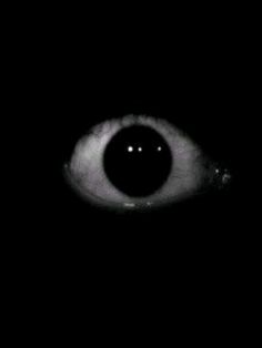 an eye is shown in the dark with only one eye visible for all to see