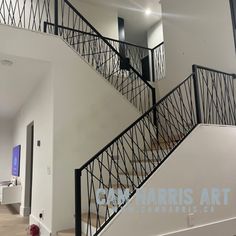 a white staircase with black handrails in an empty room on the first floor