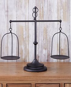 an old fashioned metal balance scale on top of a wooden table