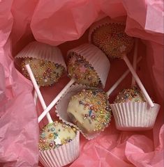 there are some cake pops with sprinkles on them in a pink bag