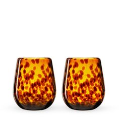 two glasses sitting next to each other on a white surface and one has brown spots