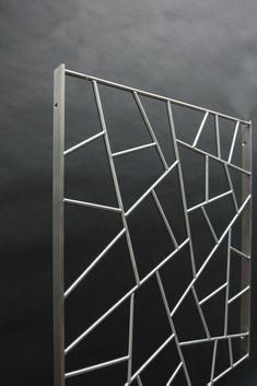 a metal sculpture on a black surface with white lines in the center and bottom part