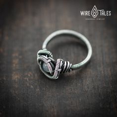 a wire wrapped ring sitting on top of a wooden table