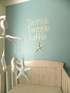 a baby crib with a starfish hanging from it's side and the words twinkle little on the wall