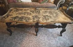 an ornately decorated coffee table sits in the middle of a room with couches