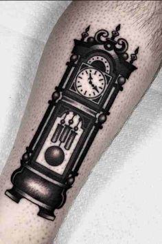 a black and white clock tattoo on the arm