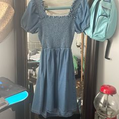 Is A Size Small, Denim Material, Has Pockets, Back Is Cut Out With A Tie Was Bought From A Local Boutique Has Never Been Worn Still Has Tags Trendy Stretch Denim Blue Dress, Blue Non-stretch Denim Mini Dress, Blue Non-stretch Mini Length Denim Dress, Washed Blue Mini Denim Dress For Day Out, Blue Mini Denim Dress, Knee-length Light Blue Mini Dress For Day Out, Casual Washed Blue Mini Denim Dress, Casual Knee-length Denim Mini Dress, Fitted Knee-length Denim Dress For Brunch