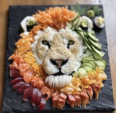 a lion made out of sushi on a slate board