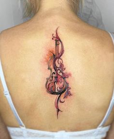 a woman with a violin tattoo on her back