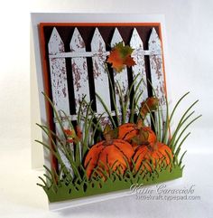 a card with pumpkins and grass in front of a white picket fence on a white background