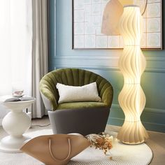 a green chair sitting next to a lamp on top of a white rug in a living room