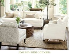 a living room filled with white furniture and lots of plants in the window sill