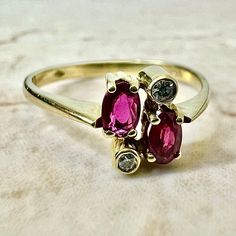 Fine vintage handcrafted 18 Karat yellow gold Toi-Et-Moi (bypass) ring set with 2 oval rubies weighing approximately 0.50 carat, and 2 round diamonds weighing approximately 0.05 carat, F-G VS. Stamped 750 with maker’s marks. This ring is a size 7.75 US / P 1/2 UK. > Resizing not included. This ring can be resized to fit most fingers. Please contact us for details. Resized rings are final sale. It weighs 2.3 grams. Birthstone: July/April. Condition: Very good. Minute scratches throughout metal. L Oval Multi-stone Ruby Ring, Oval Multi-stone Ruby Ring In Yellow Gold, Oval Ruby Ring With Diamond Accents In 14k Gold, Oval Ruby Ring With Three Diamonds, Oval Three Stone Ruby Ring With Diamonds, Oval Multi-stone Ruby Ring For Anniversary, Gold Oval Ruby Ring With Diamond Accents, Oval Multi-stone Ruby Ring In 14k Gold, Gold Oval Ruby Ring With Three Stones