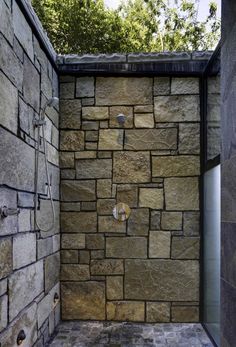 an outdoor shower with stone walls and tile flooring