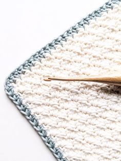 a crocheted dishcloth with a wooden spoon on it and a white background