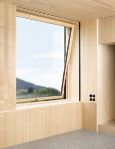 an open window in a room with wood paneling