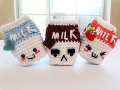 three crocheted coffee mug cozyies sitting on top of a white table next to a window