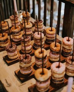 donuts are arranged on wooden trays with candles in the middle and chocolate drizzled on them