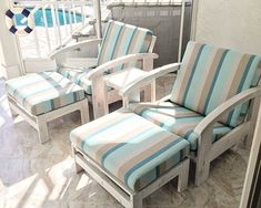 two chairs and a footstool sitting on a porch next to a pool with water in the background