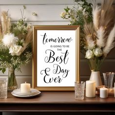 a table topped with vases and candles next to a framed sign that says tomorrow is going to be the best day ever