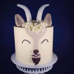 a close up of a cake on a plate with flowers in the shape of deer's head