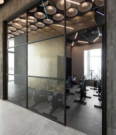 an empty gym with treadmills and exercise machines in the background, as seen through glass doors