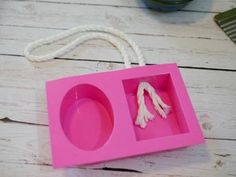 a pink tray with two pieces of food in it sitting on a table next to a comb and scissors