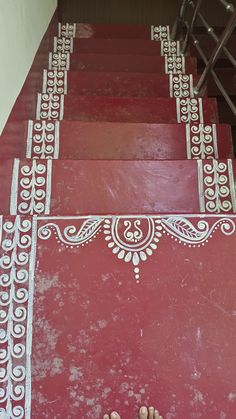 two feet are standing on red steps with white designs