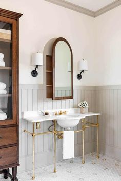 a bathroom with two sinks and a cabinet in the corner next to it, along with white towels