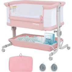 the baby crib is pink and has its changing tray on it's side