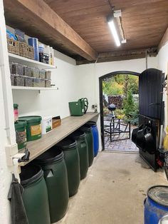 the inside of a garage with lots of buckets and other items on the shelves