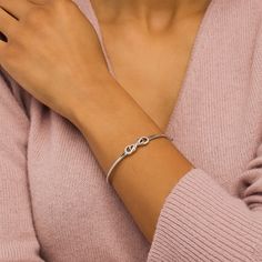 This cute diamond infinity bangle adds a touch of sparkle to any attire. Crafted in sterling silver, this look showcases a diamond-lined infinity loop layered with a smaller polished infinity symbol. Radiant with 1/5 ct. t.w. of diamonds and a brilliant buffed luster, this hinged bracelet measures 7.0 inches in circumference and secures with a tongue and groove clasp. Fine Jewelry Infinity Stackable Pieces, Formal Stackable Infinity Jewelry, Elegant Infinity Stackable Jewelry, Adjustable Infinity Fine Jewelry, Sterling Silver Stackable Infinity Jewelry, Silver Infinity Bracelets With Diamond Accents, Silver Infinity Stackable Jewelry, Silver Stackable Infinity Jewelry, Elegant Stackable Jewelry For Mother's Day