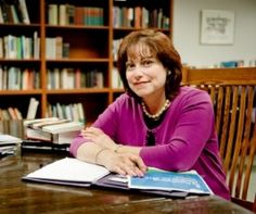 a woman sitting at a table in front of books