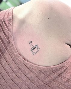 a woman with a small tattoo on her left shoulder and coffee cup in the middle