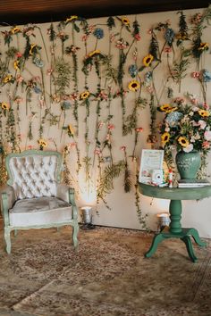 a chair and table with flowers on the wall