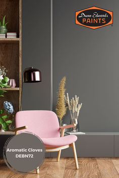 a pink chair sitting in front of a gray wall