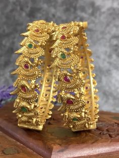 Temple bangle in matte gold and ruby stone. Detailing has the Rajasthani similarity. Comes in a pair . Can be bought in pair as well. About half an inch think. Ruby Stone, Matte Gold, Earring Necklace, Shop Earrings, Temple, Ruby, Crown Jewelry, Bangles, Stone