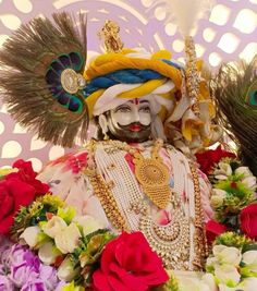 an elaborately decorated statue with feathers and flowers