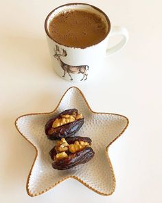 two pieces of fruit on a star shaped plate next to a cup of hot chocolate