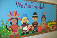 a bulletin board that says we are grateful with children dressed in native american clothing and holding an arrow