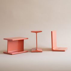 three different colored tables and stools on a white surface