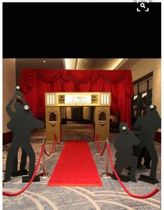 red carpeted entrance way with two statues on each side and a red carpet leading up to the door