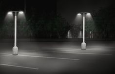 three street lights in the middle of a parking lot at night with no one on it