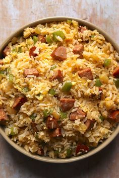 a bowl filled with rice, sausage and green peppers