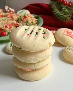 a stack of cookies sitting on top of a white table next to plates of food