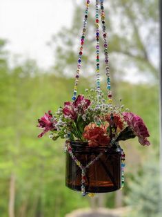 a hanging planter filled with flowers and beads