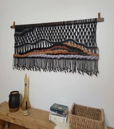 the wall hanging is made out of woven material and has fringes on top of it