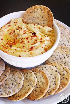 a white plate topped with crackers and dip